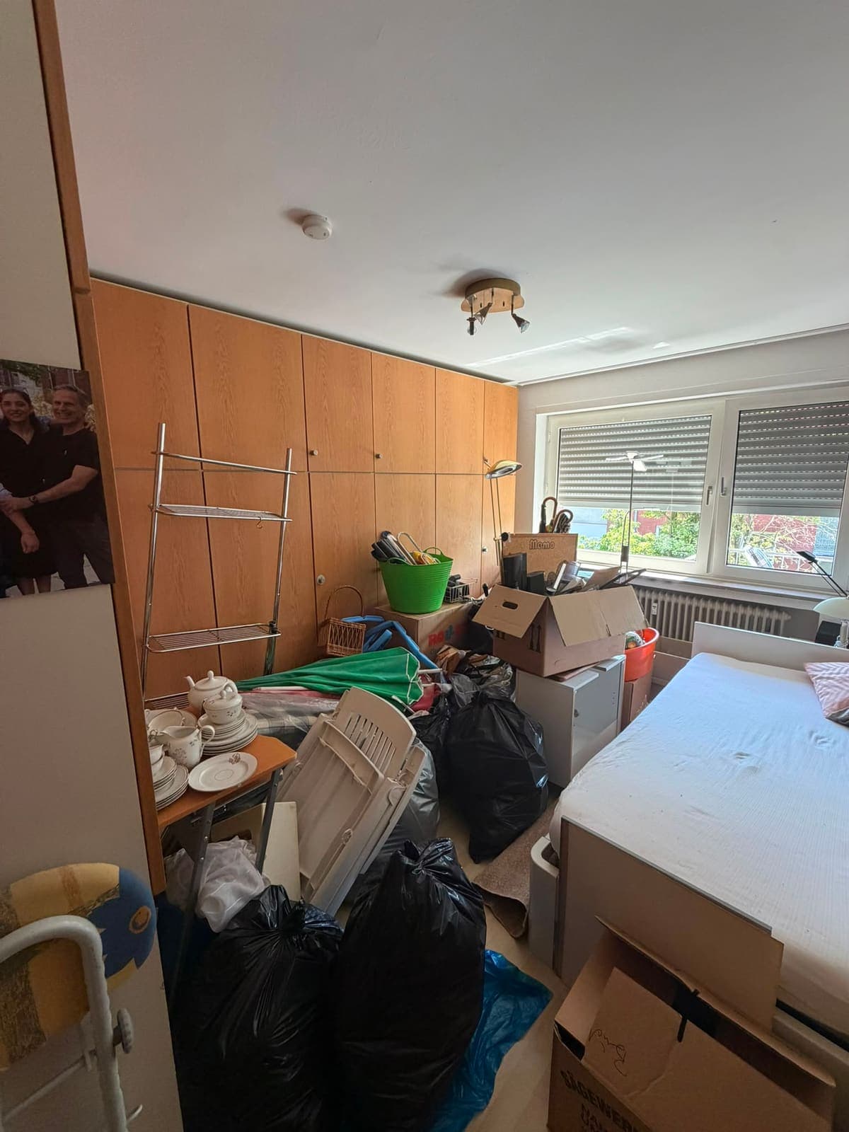 Schlafzimmer voller Kartons, Säcke und Möbel vor der Wohnungsauflösung